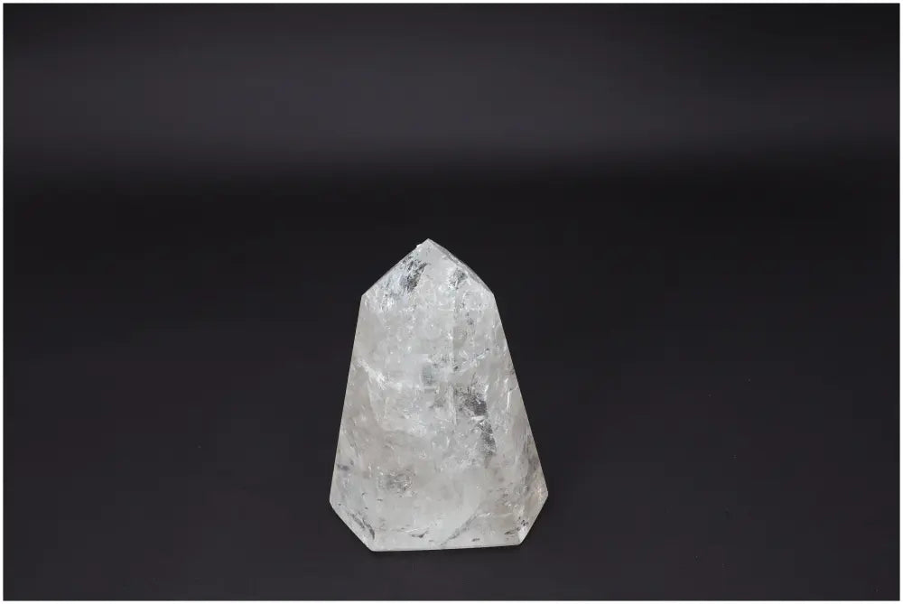 Lemurian Quartz Obelisk: Clear quartz crystal on dark background symbolizing clarity, balance, and personal growth.