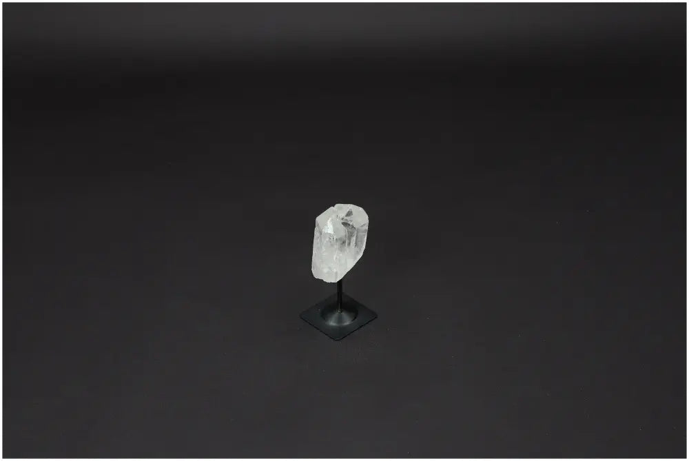 Lemurian Quartz crystal on a sleek metal stand against a dark background, known for clarity and balance in personal growth.