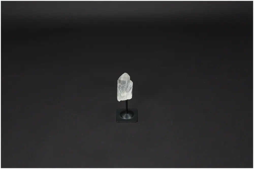 Lemurian Quartz on a metal stand against a dark background, representing clarity and balance in crystal healing.