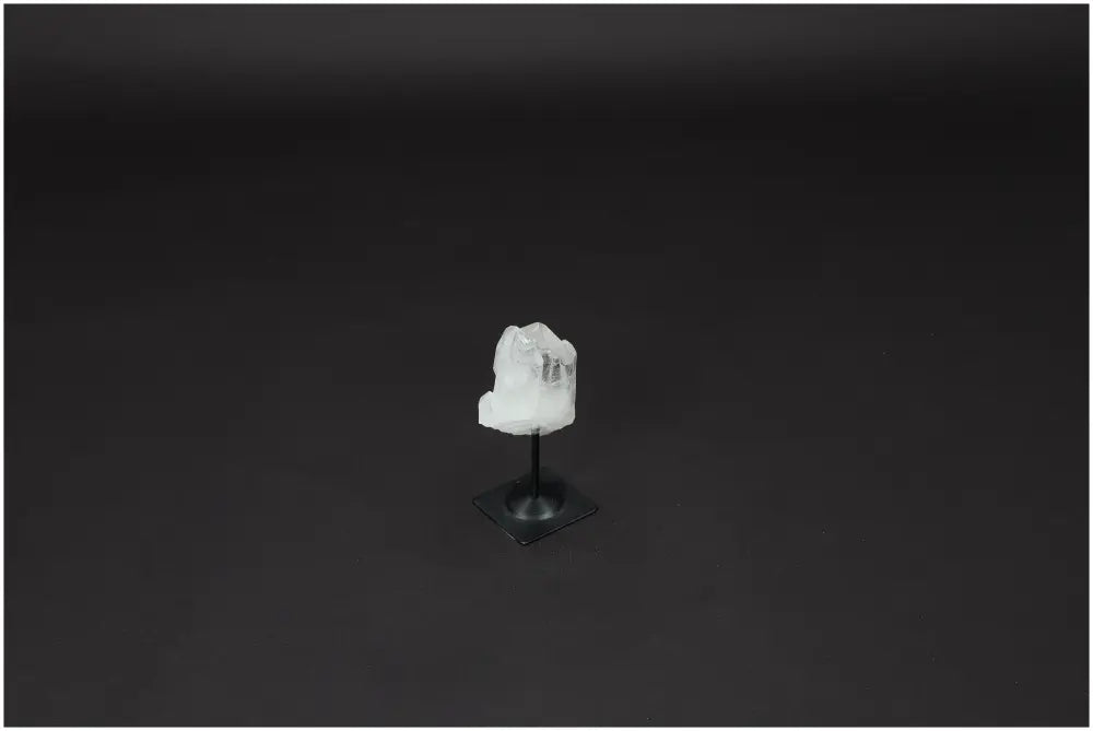 Lemurian Quartz crystal on a metal stand against a dark background, highlighting its clarity and elegance.