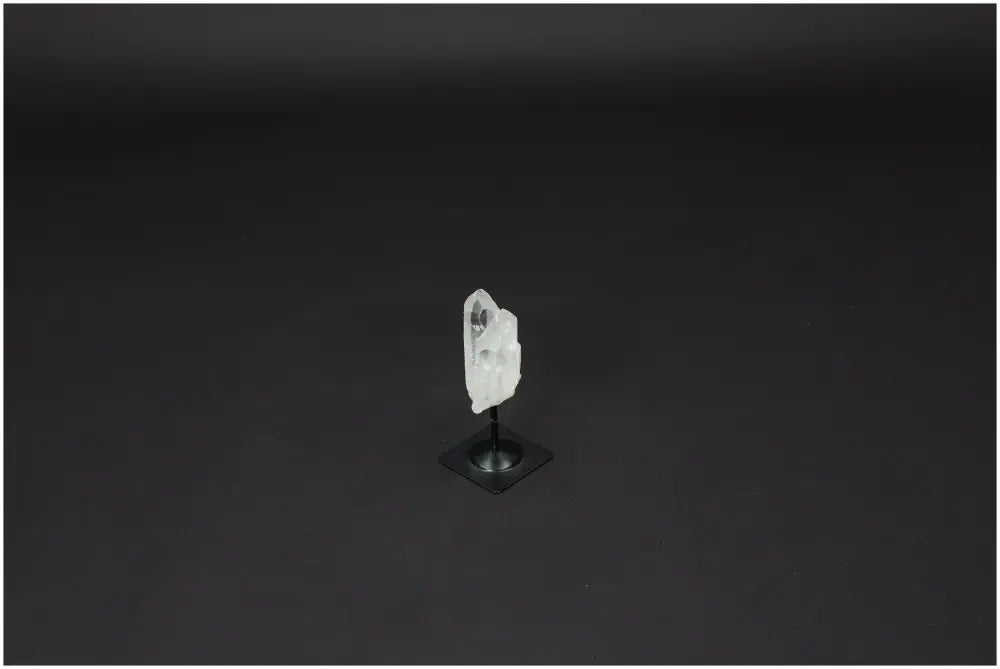 Lemurian Quartz on metal stand against black background, showcasing the crystal's clear structure for clarity and balance.