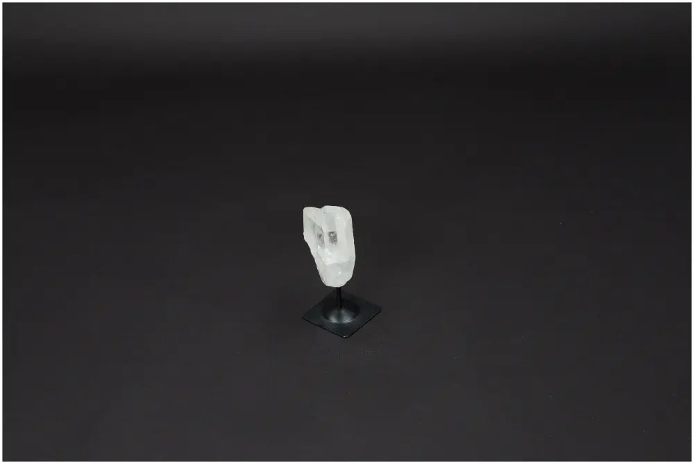 Lemurian Quartz Crystal on sleek metal stand against a dark background, showcasing its natural clarity and elegance.