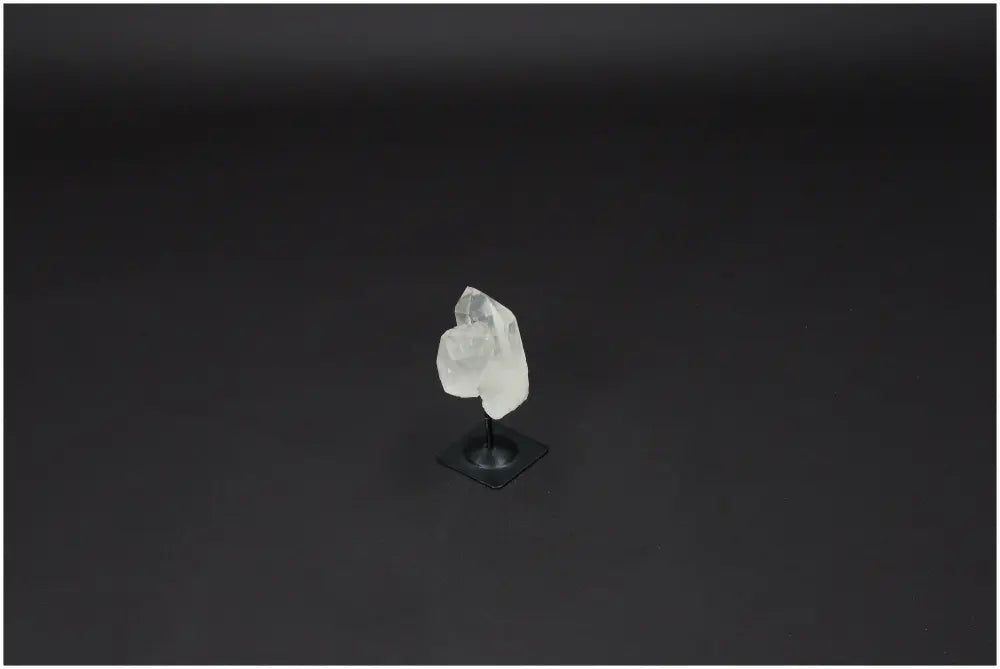 Lemurian Quartz crystal on metal stand against dark background, ideal for purification and neutralizing negative vibrations.