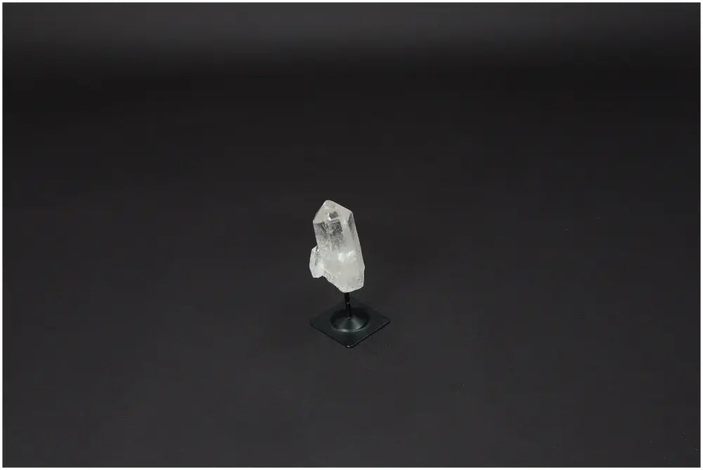 Lemurian Quartz on metal stand, showcasing the clear quartz's purification and harmonizing properties against a dark background.