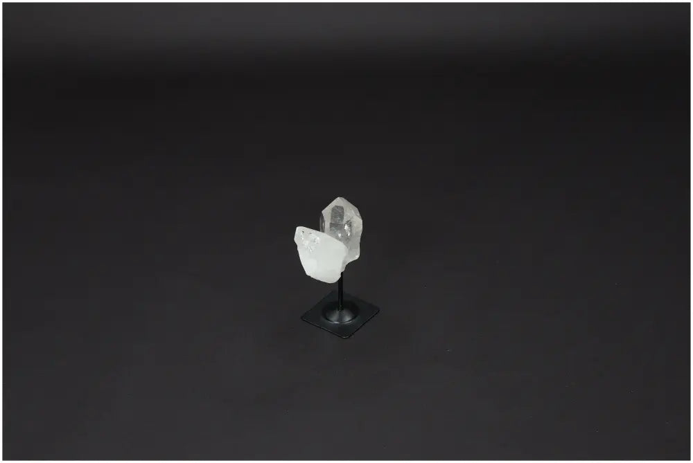 Lemurian Quartz crystal on elegant metal stand against dark background, known for purification and absorbing negative energy.
