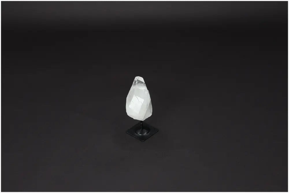 Lemurian Quartz on metal stand, a purification stone for harmonizing energy and neutralizing negative vibrations, against a dark background.
