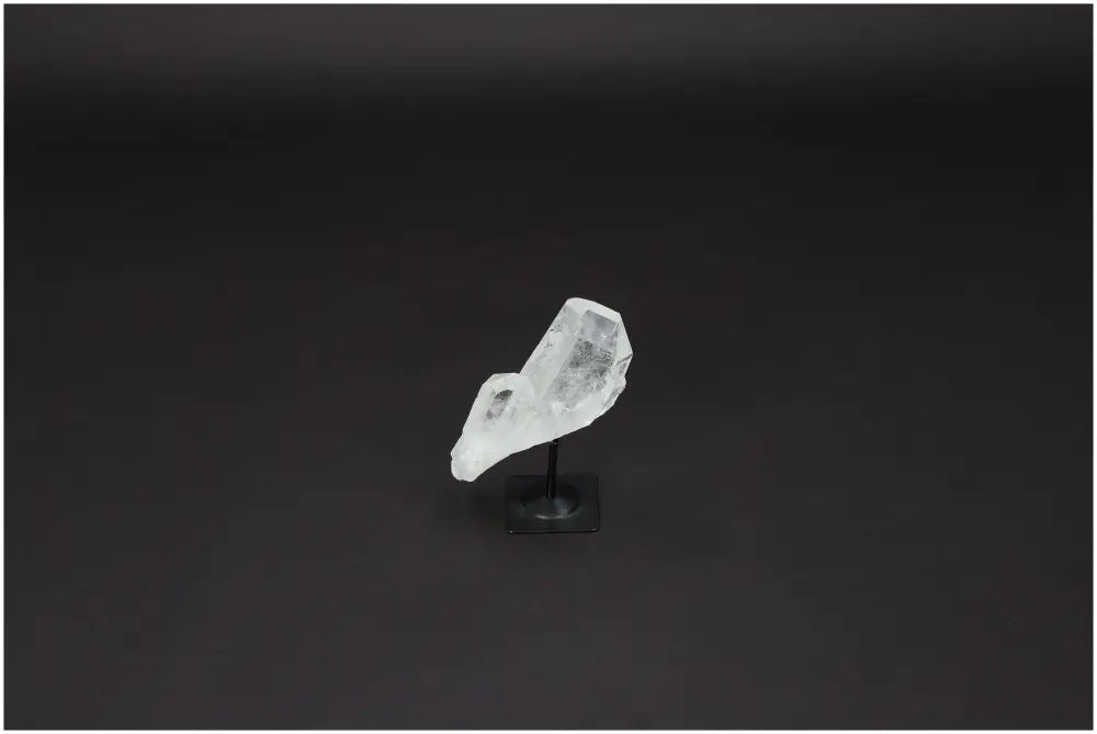Lemurian Quartz on metal stand against dark background, ideal for energy purification and harmonizing space.