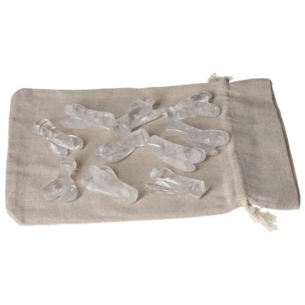 Collection of clear quartz Lemurian small angel sculptures on a fabric pouch, ideal for energy purification and space cleansing.