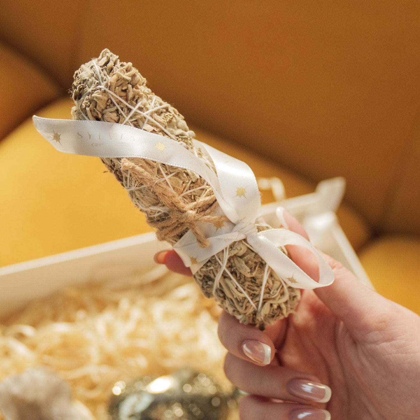 Sage smudge stick wrapped in ribbon, part of the Love and Wealth Gift Box with crystals for enhancing love and prosperity.