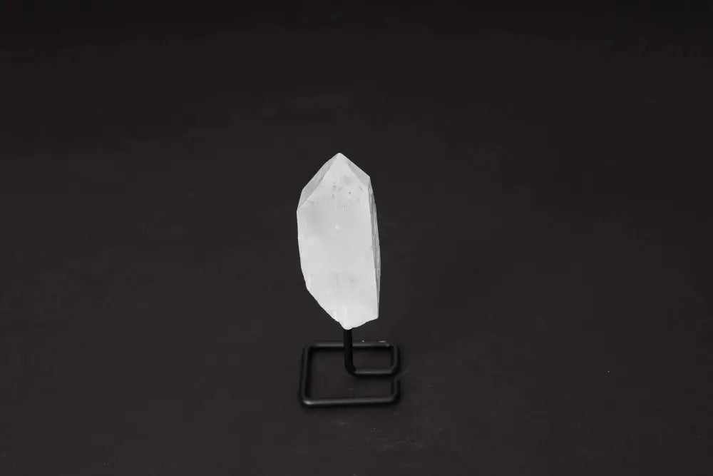 Clear Quartz point on stand, ideal for energy amplification and clarity, showcased on a modern display for home or meditation spaces.