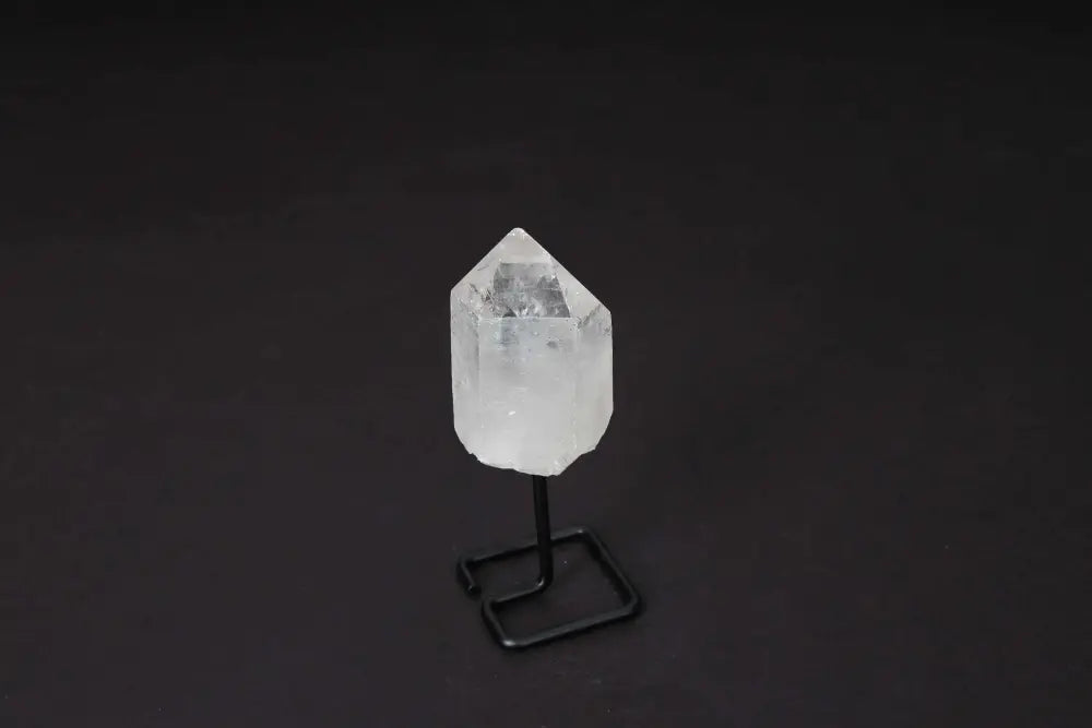 Natural Clear Quartz Point on modern stand for energy amplification and meditation.