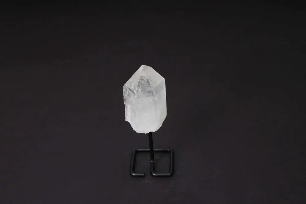 Natural Clear Quartz Point on a modern stand, ideal for meditation and energy work, amplifies clarity and intention.