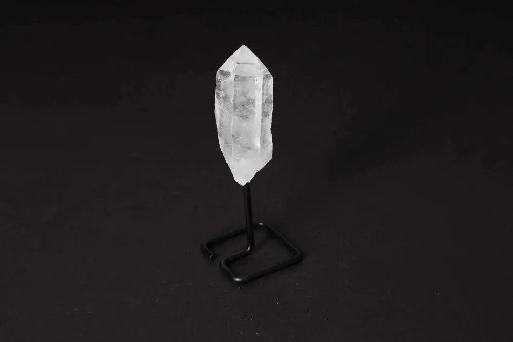 Natural clear quartz point on modern stand, perfect for amplifying energy and clarity in meditation or energy work.