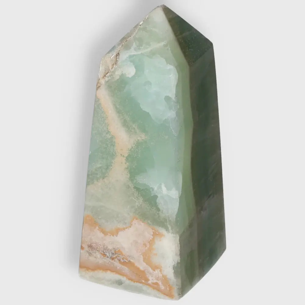 Pistachio Calcite Tower crystal with pale green hues, perfect for bringing calm and harmony to any space through its soothing energy.