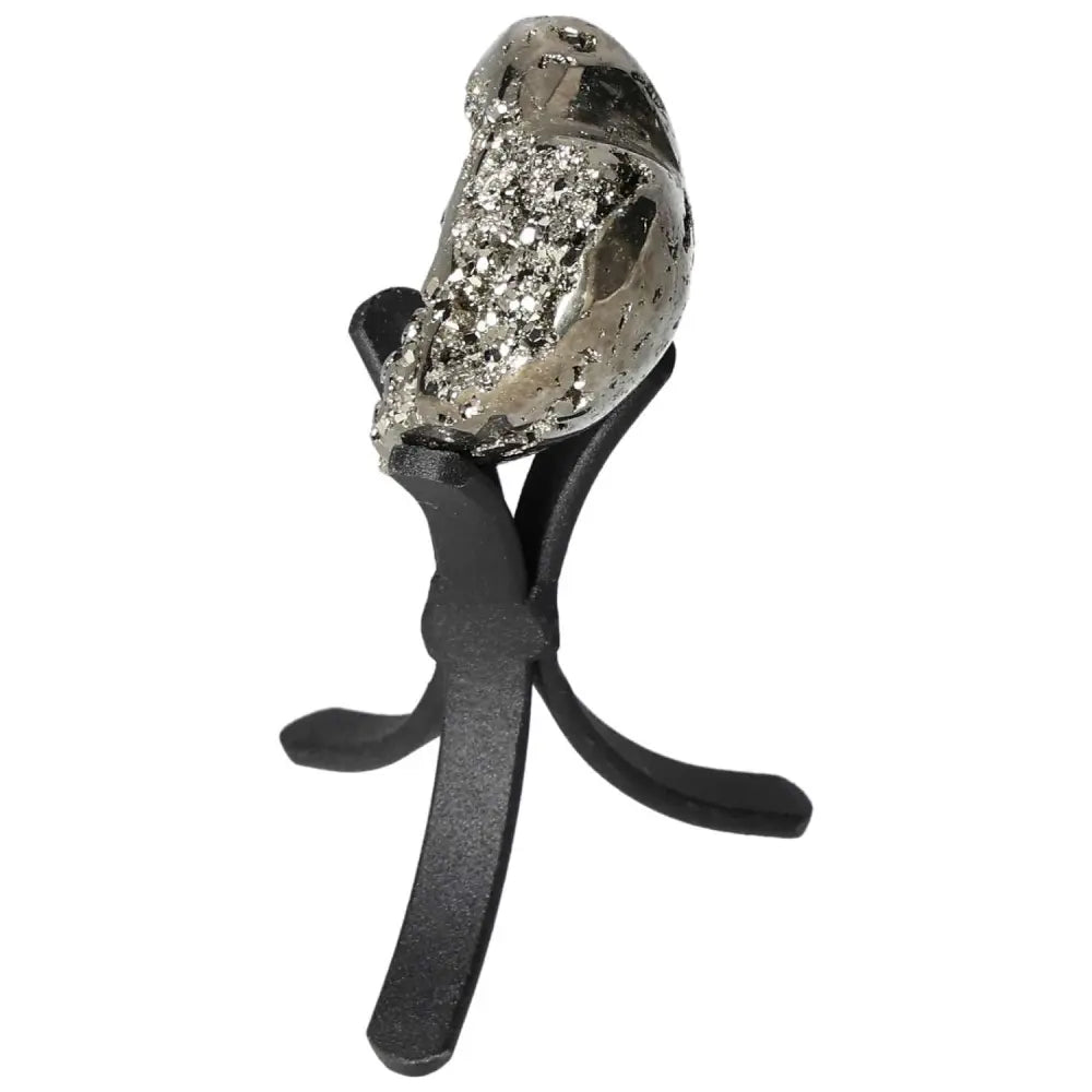 Polished pyrite heart on a black stand, showcasing golden luster and energy-enhancing properties. Ideal for decor and spiritual spaces.