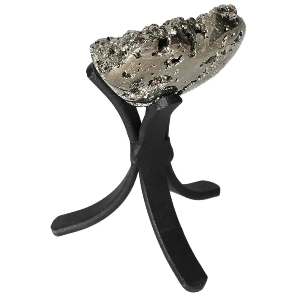 Polished pyrite heart with golden luster on a black stand, highlighting grounding energy and elegant design.
