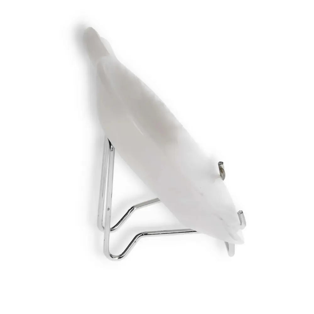 White ceramic bird sculpture on a sleek metal stand, viewed from the side.
