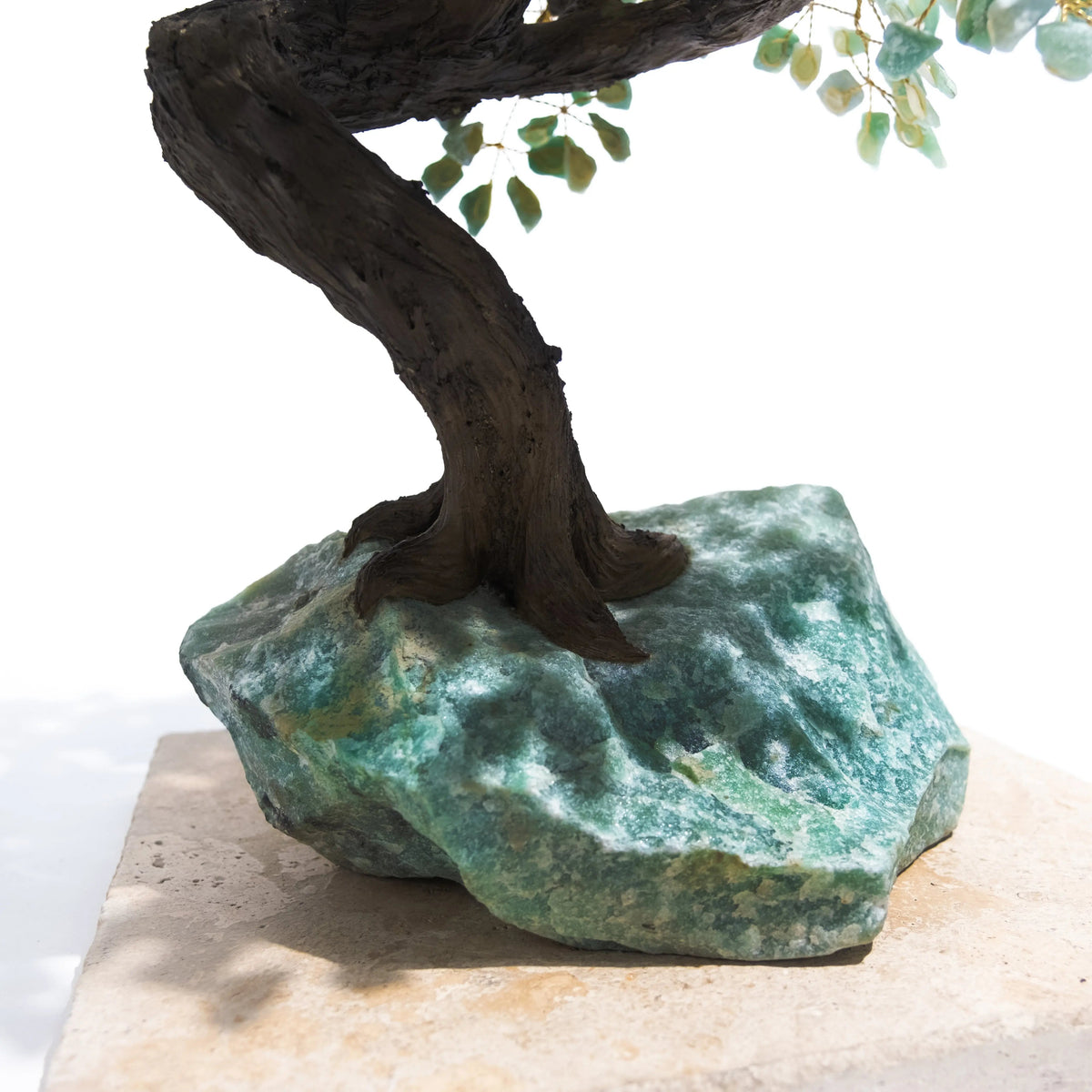 Close-up of hand-crafted Rough Aventurine Tree base, symbolizing positive energy and prosperity, set against a light background.