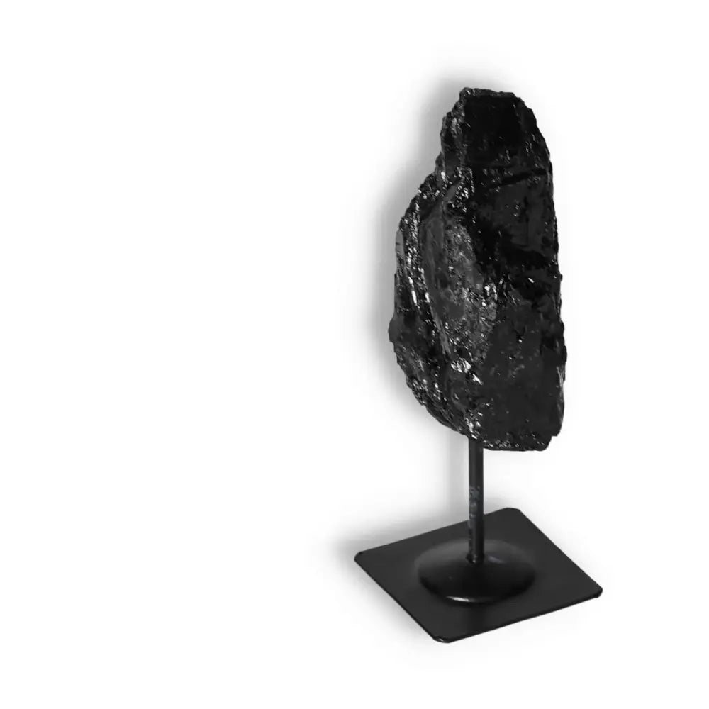 Rough Black Tourmaline on Metal Stand by Sylvia Crystals, known for cleansing negative energies, symbolizing conscious luxury and elegance.