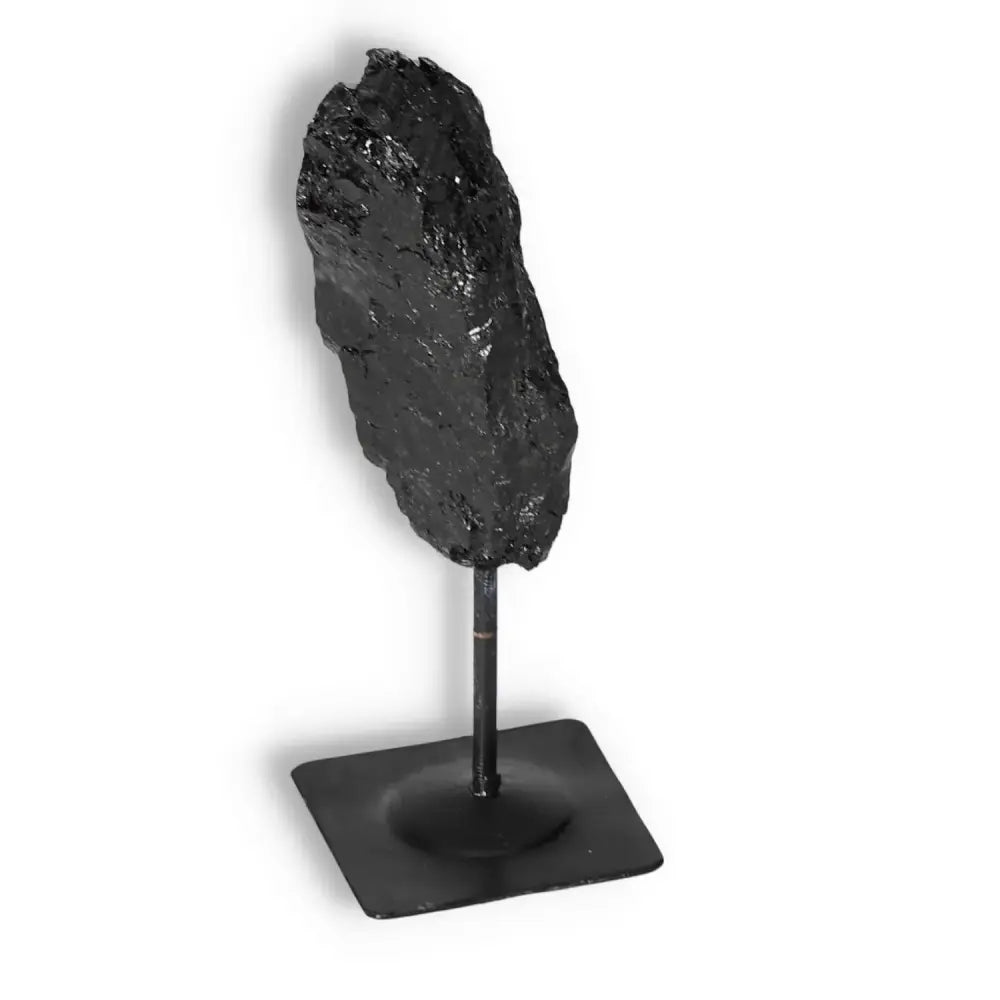 Rough Black Tourmaline with Metal Stand by Sylvia Crystals, known for cleansing negative energy, featuring raw beauty and elegance.