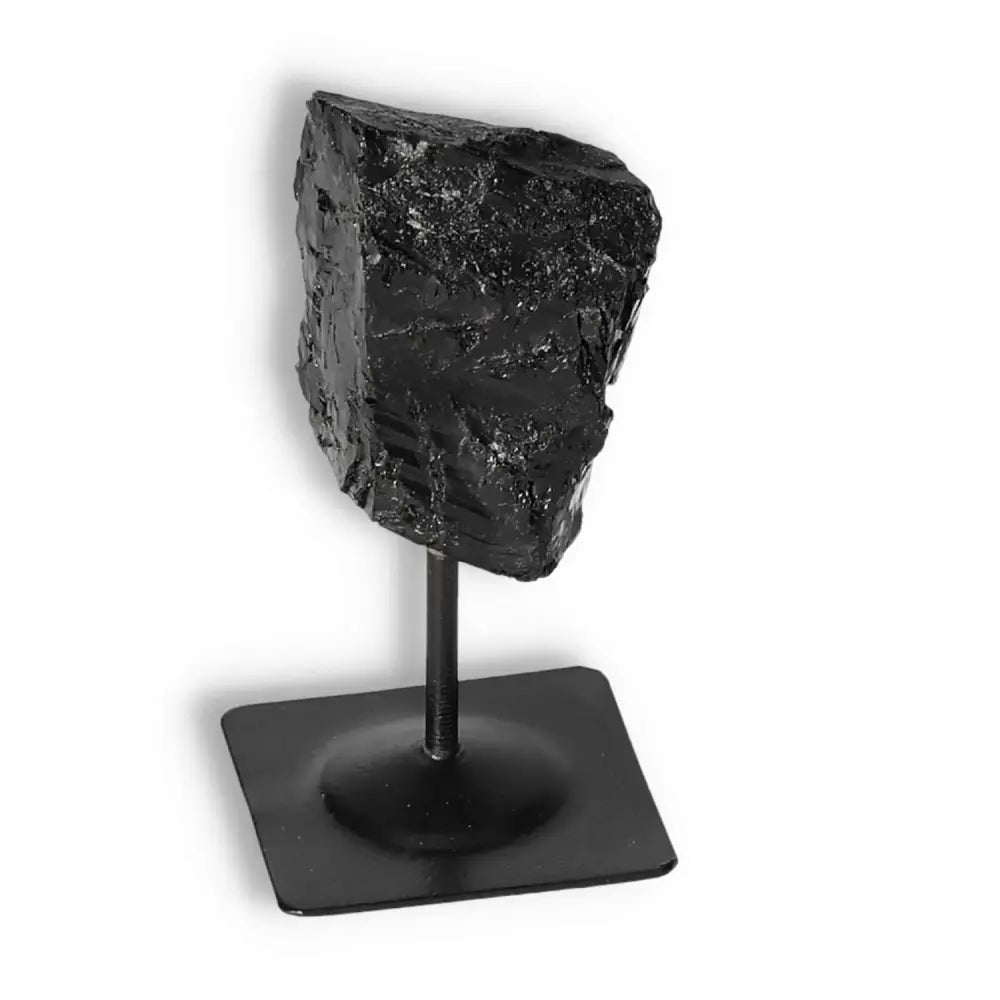 Rough Black Tourmaline on sleek metal stand from Sylvia Crystals, showcasing elegance and powerful cleansing properties.
