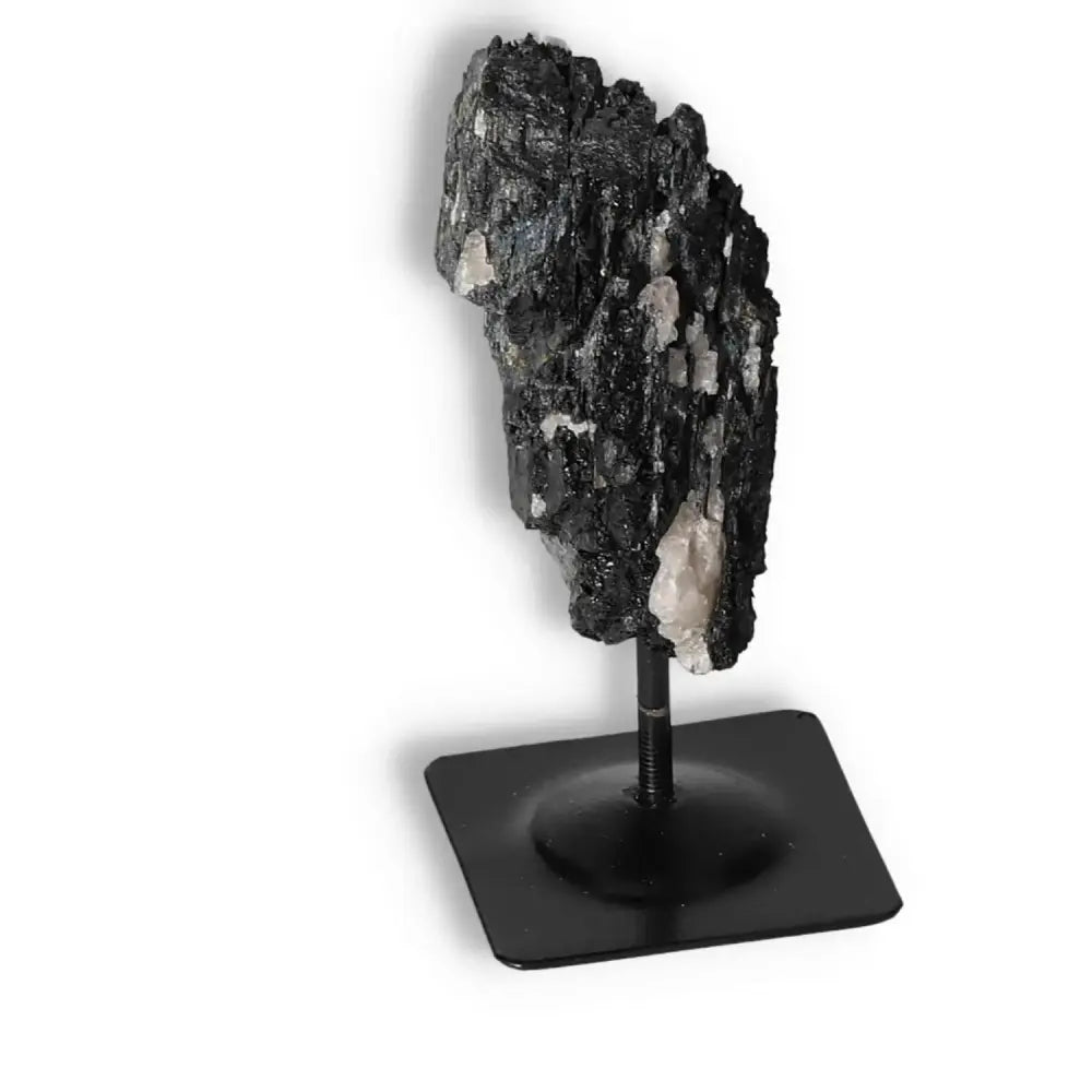 Rough Black Tourmaline with Metal Stand S displayed on a black base, showcasing natural texture and cleansing energy qualities.