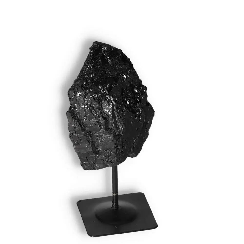 Rough Black Tourmaline on metal stand by Sylvia Crystals, showcasing premium quality and transformative cleansing properties.
