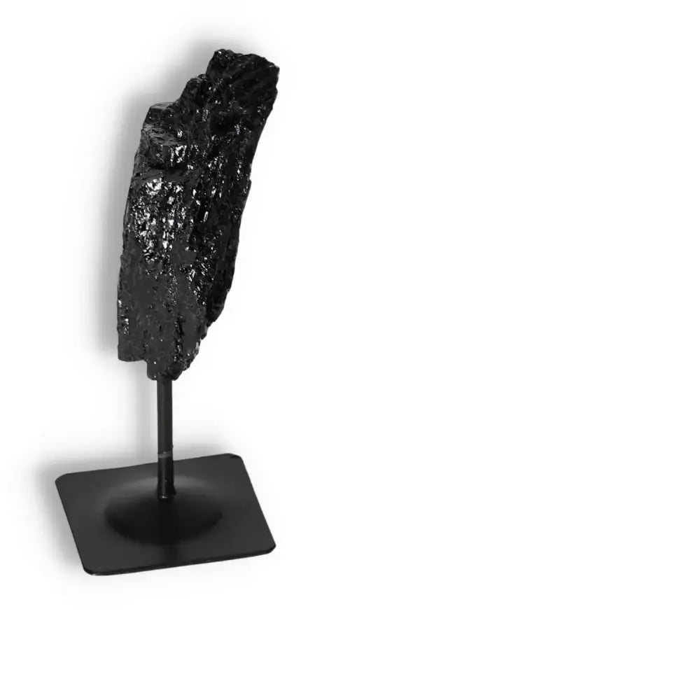 Rough Black Tourmaline on metal stand from Sylvia Crystals, known for cleansing negative energies and quality craftsmanship.