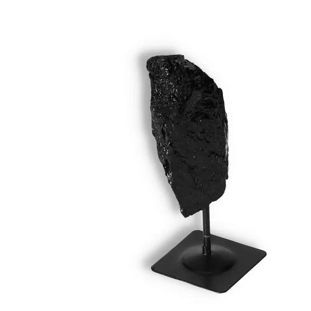 Rough Black Tourmaline with metal stand S by Sylvia Crystals, known for transforming negative energies with powerful cleansing properties.