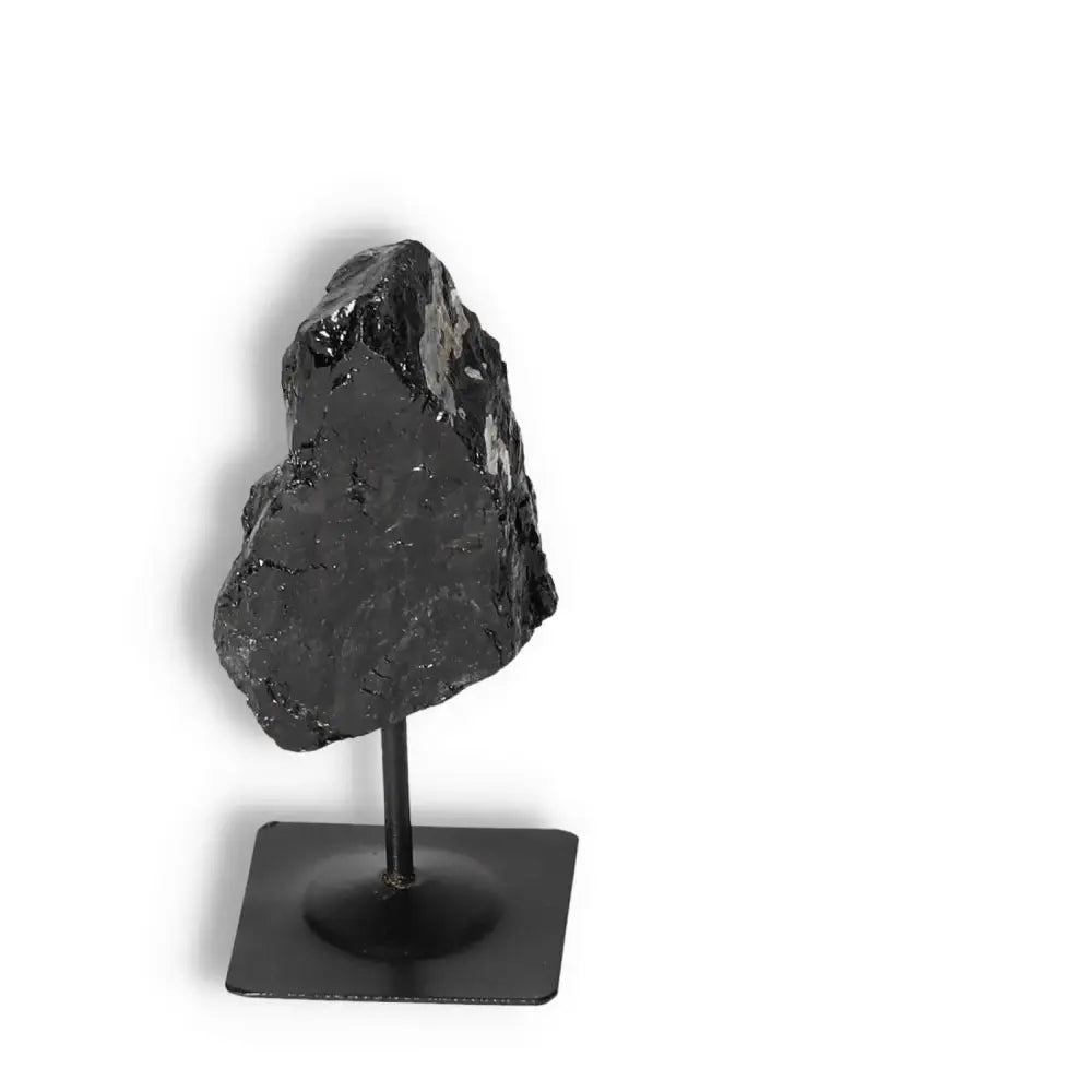 Rough Black Tourmaline on metal stand, offered by Sylvia Crystals, enhances spiritual wellbeing and negates negative energies.