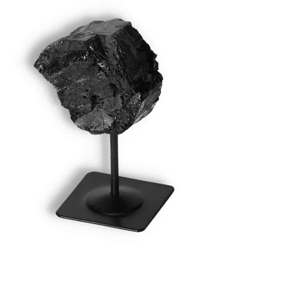 Rough black tourmaline crystal on metal stand, ideal for energy cleansing and spiritual grounding, from Sylvia Crystals collection.