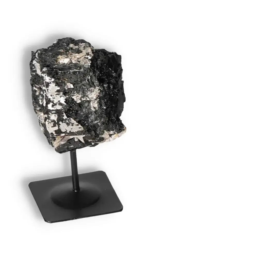 Rough Black Tourmaline on a metal stand, ideal for transforming negative energies and promoting mental balance. From Sylvia Crystals.