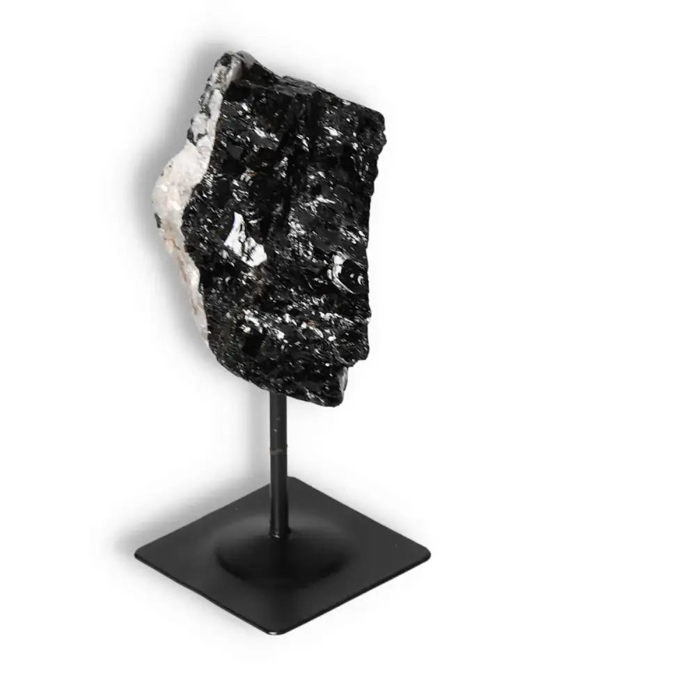 Elegant Rough Black Tourmaline on Metal Stand from Sylvia Crystals, known for grounding and protection against negative energies.