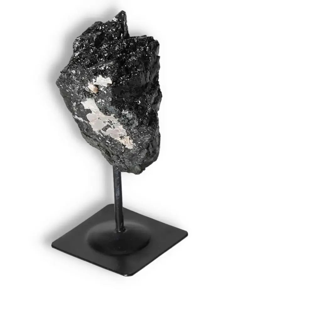 Rough Black Tourmaline on sleek metal stand from Sylvia Crystals offers energy cleansing and protection; perfect for any home decor.