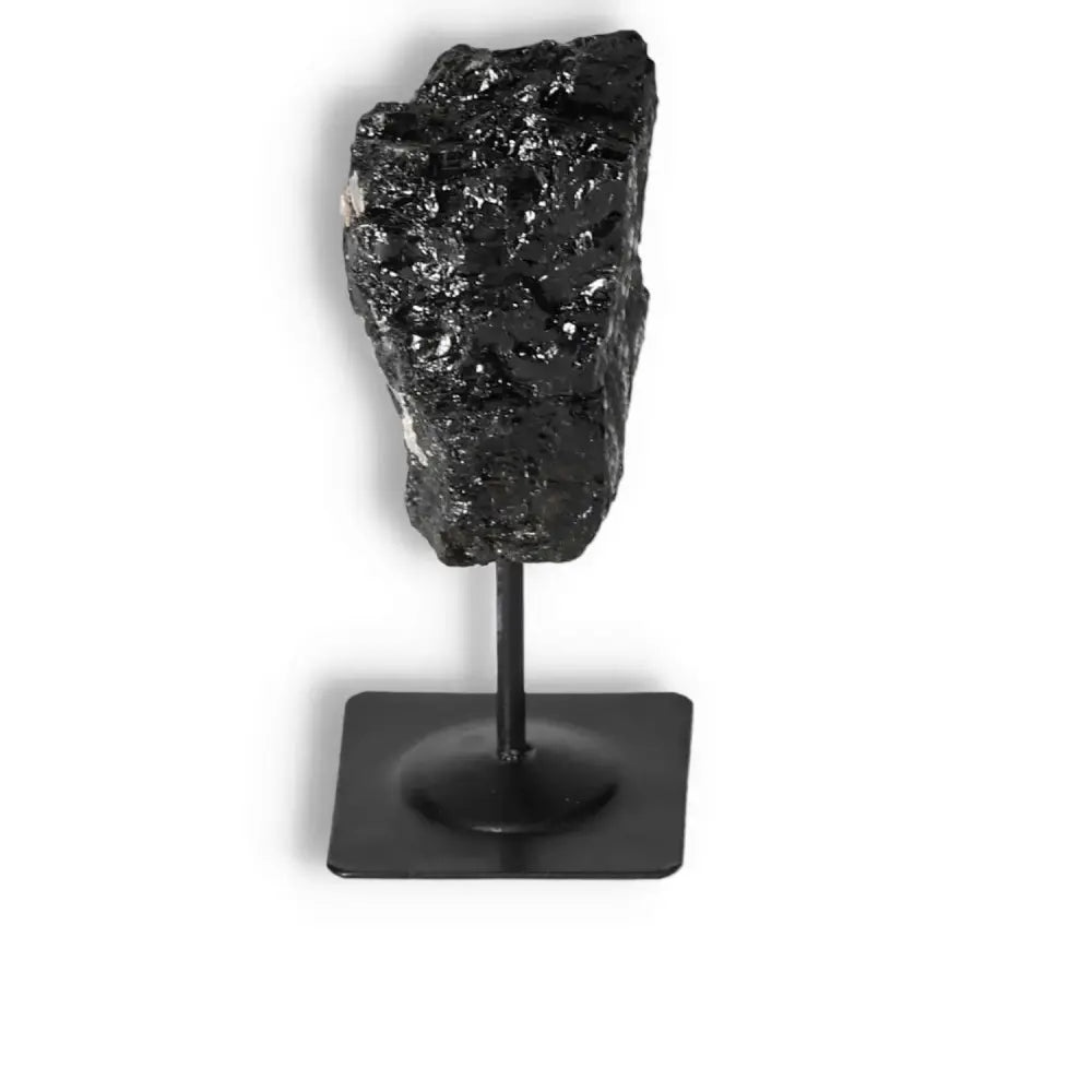 Rough Black Tourmaline with metal stand from Sylvia Crystals, known for cleansing negative energies, stylish for any decor.
