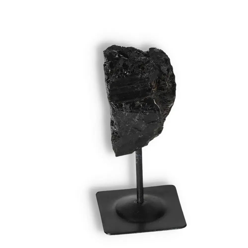 Rough Black Tourmaline with sleek metal stand, ideal for cleansing energy and enhancing interiors, by Sylvia Crystals.