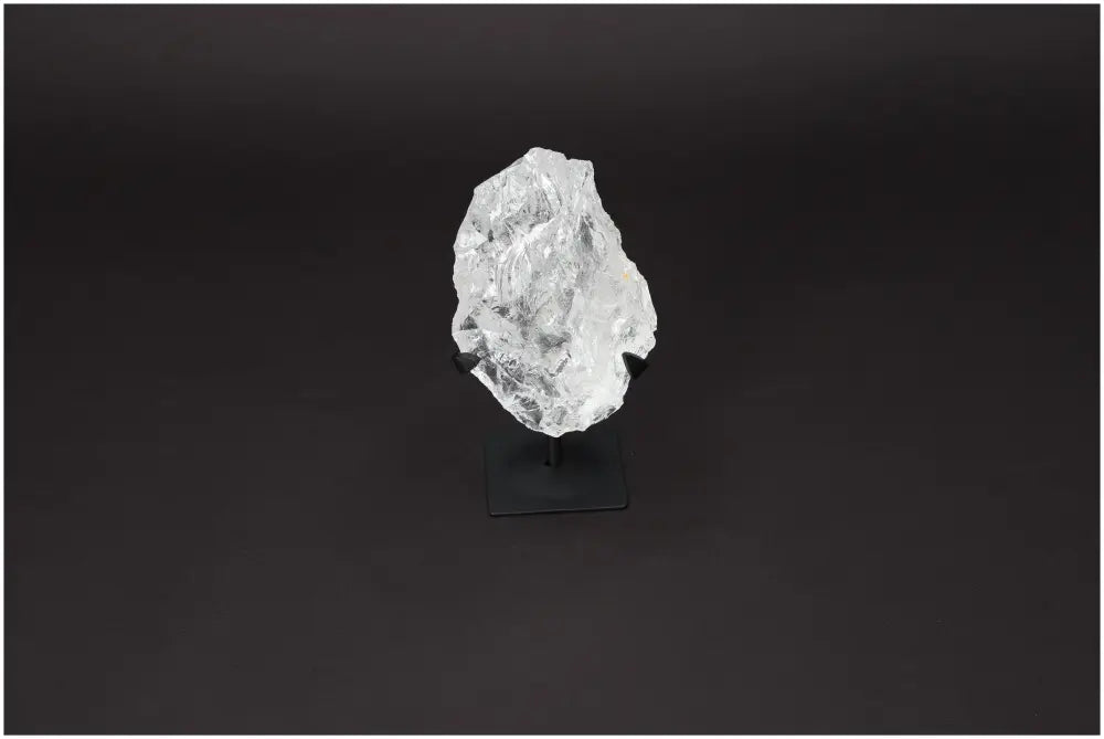 Rough Lemurian Clear Quartz Crystal on black metal stand for spiritual décor and purification, by Sylvia Crystals.