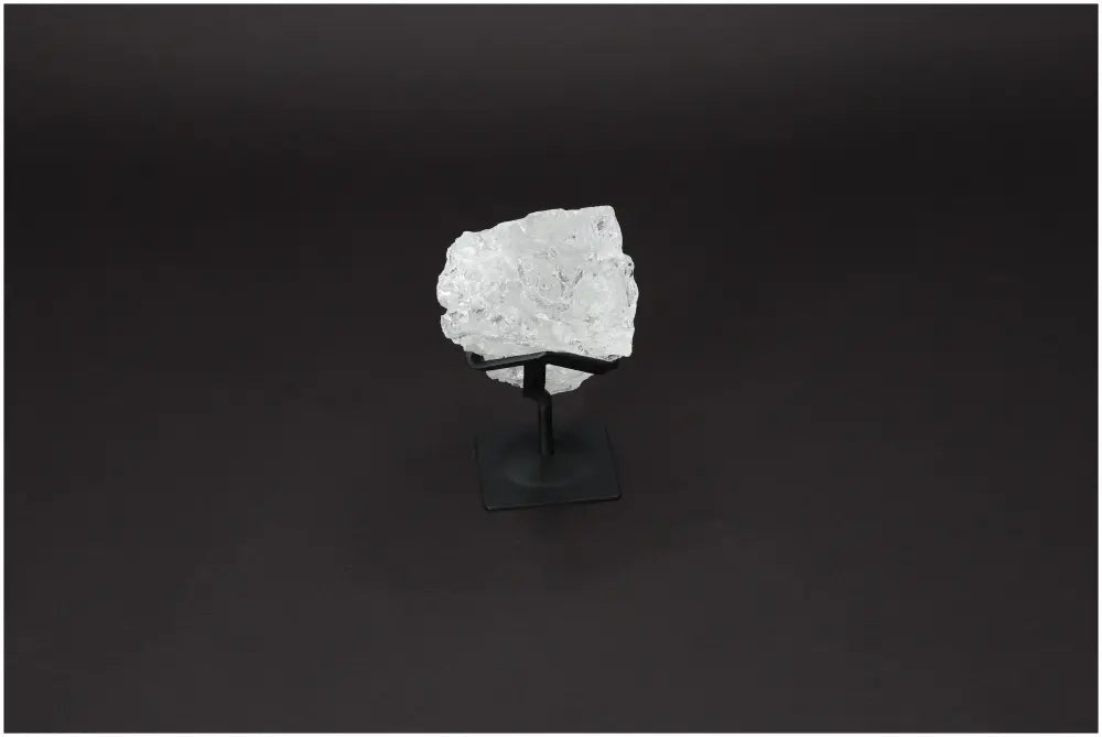 Rough Lemurian Quartz on metal stand against black background, showcasing its purifying energy and elegance for harmony and spiritual connection.