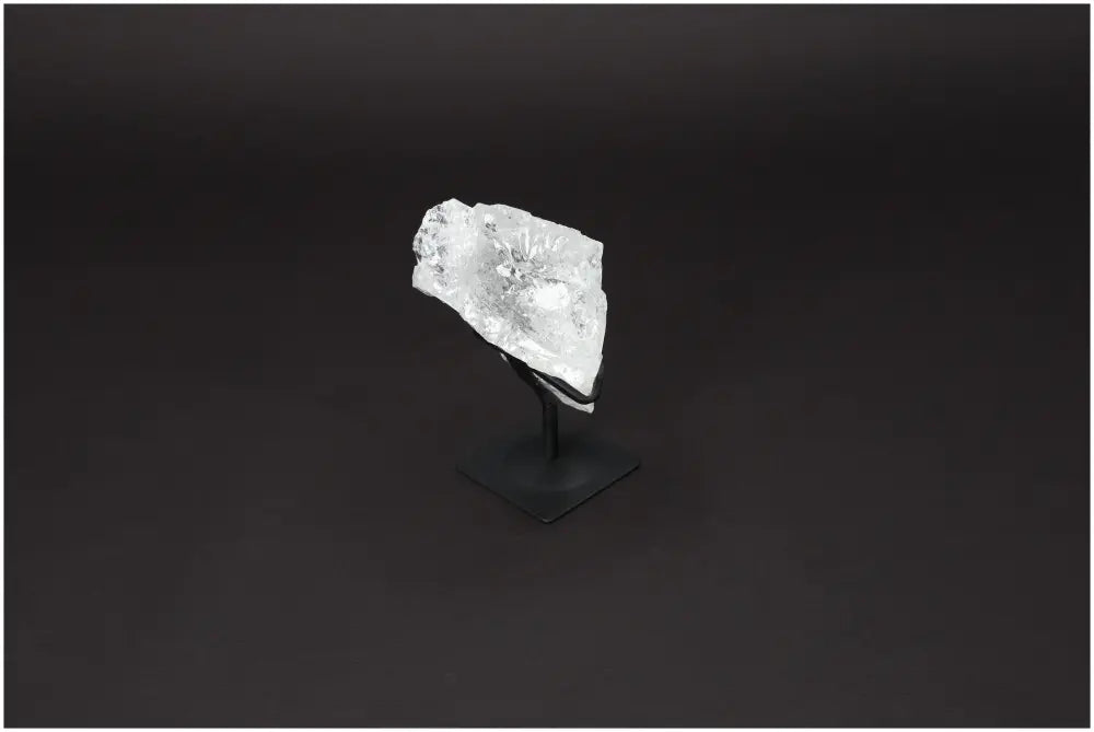 Rough Lemurian Quartz on metal stand, showcased on a dark background, highlighting its clear crystal structure, luxury, and elegance.