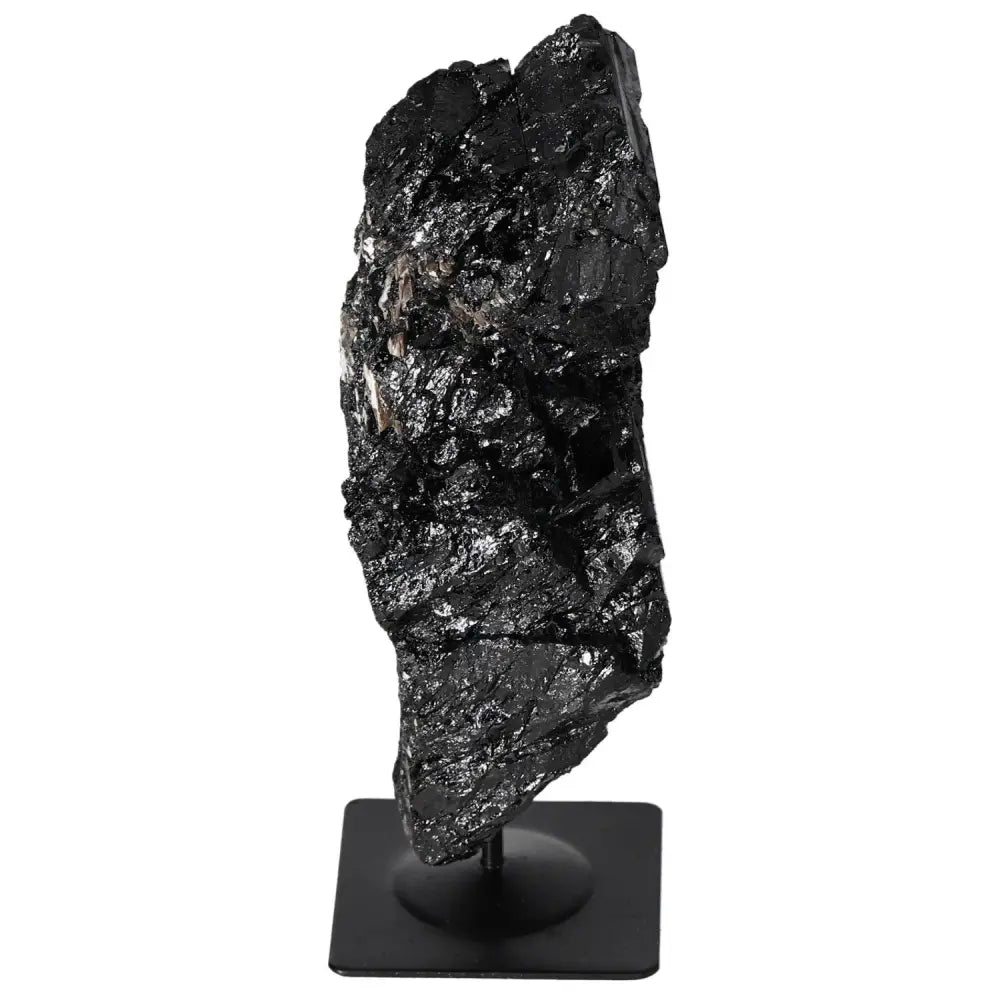 Elegant rough tourmaline stone on metal stand from Sylvia Crystals, showcasing natural beauty and tranquility for interior decor.