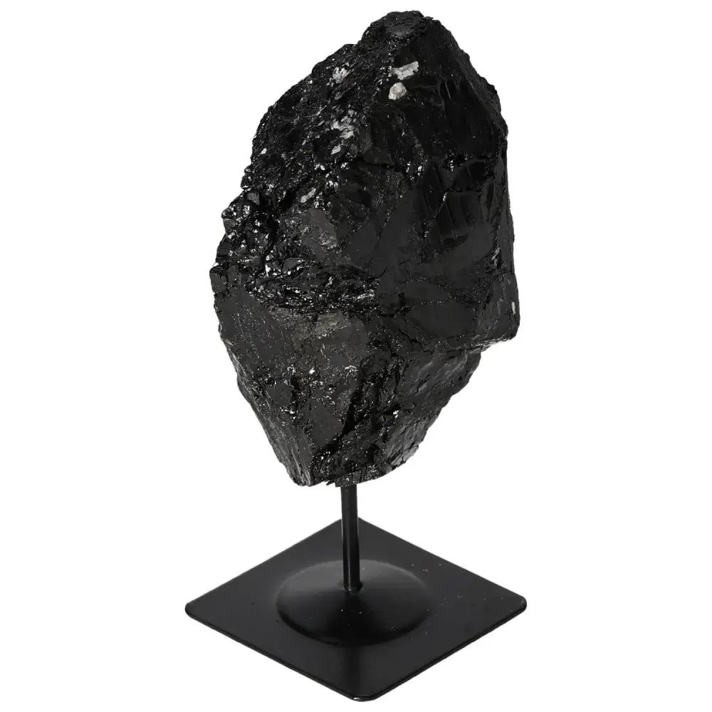 Rough black tourmaline crystal on sleek metal stand, enhancing interior decor with mystical charm.
