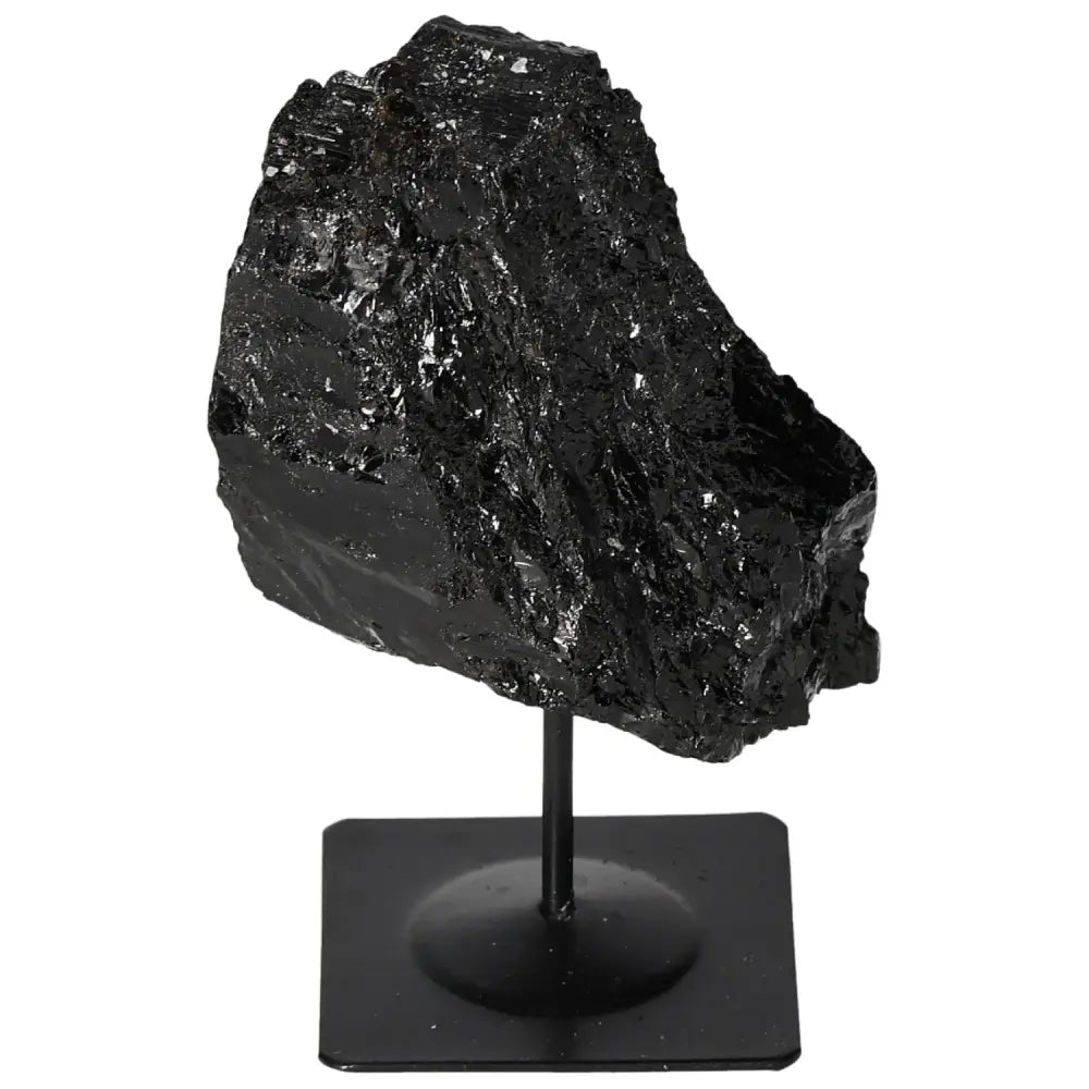 Rough tourmaline crystal on a metal stand, showcasing its natural deep black hues and energy-balancing properties.