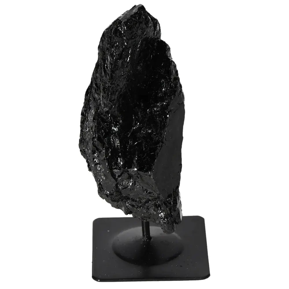 Rough tourmaline crystal on a metal stand, showcasing deep black shades, enhancing energy balance and elegance in any space.