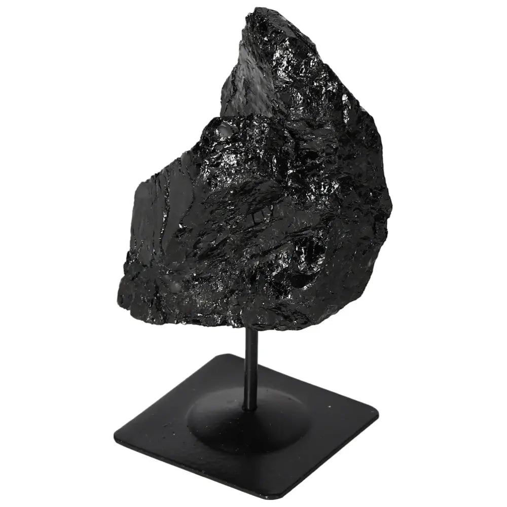 Rough black tourmaline crystal on a metal stand, showcasing its natural form and energy-balancing properties by Sylvia Crystals.