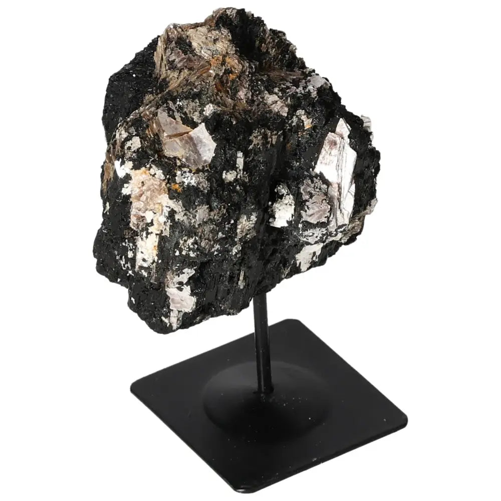 Rough tourmaline on a sleek metal stand showcasing its natural elegance and mystique, ideal as an interior centerpiece. Sylvia Crystals.