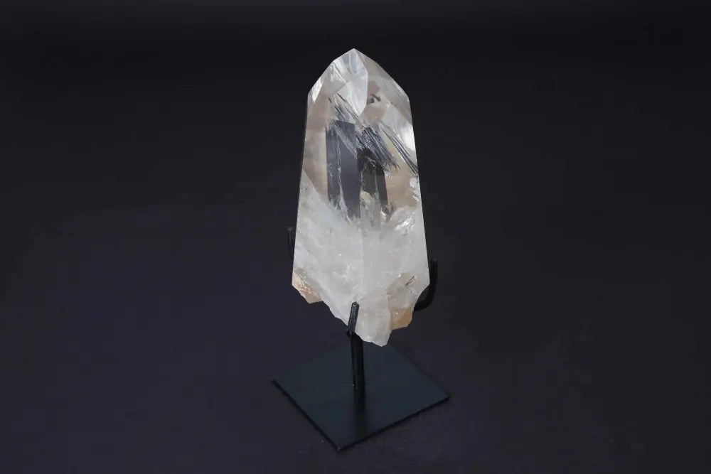 Semi polished clear quartz point with modern stand, amplifying energy for meditation and clarity. Elegant centerpiece for any space.