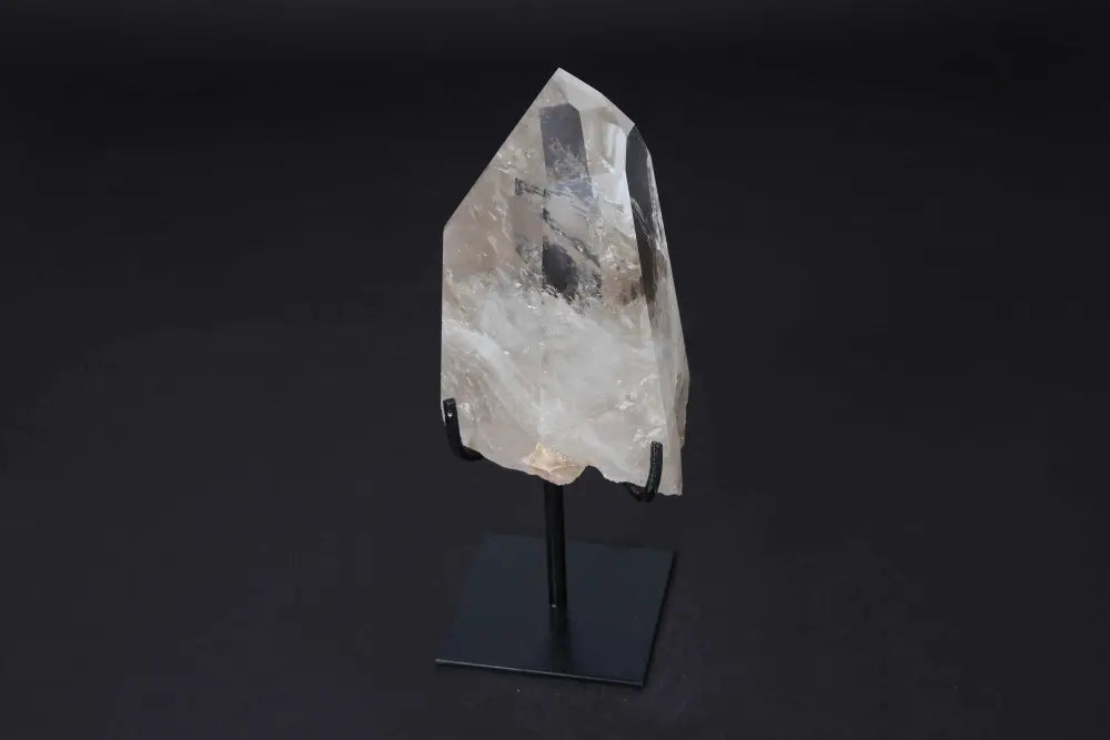 Semi polished clear quartz point with stand, ideal for amplifying energy, meditation, and enhancing clarity. Elegantly displayed on modern stand.