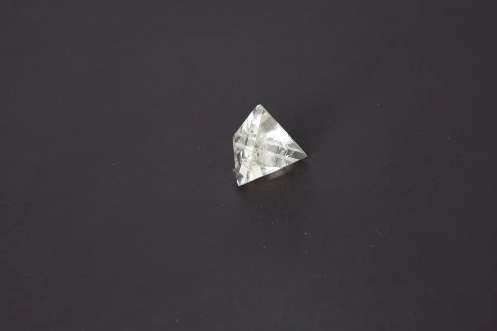 Smoky Quartz Pyramid 4 cm on dark background, showcasing grounding and neutralizing energy properties in a beautifully carved form.