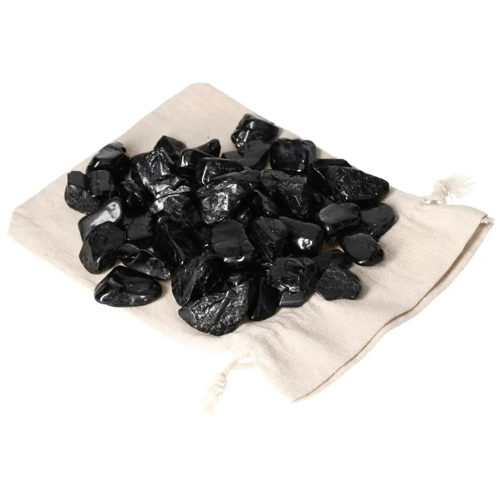 Tumbled Black Tourmaline stones on a cloth bag, ideal for spiritual grounding and protection, from Sylvia Crystals.