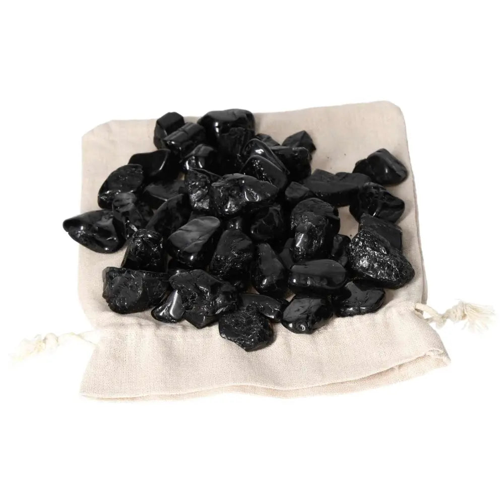 Tumbled Black Tourmaline M stones on a beige bag from Sylvia Crystals.